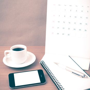coffee,phone,notepad and calendar on wood table background vintage style
