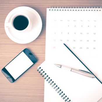 coffee,phone,notepad and calendar on wood table background vintage style