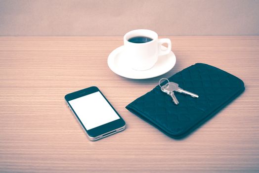 coffee phone key and wallet on wood table background vintage style