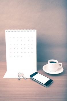 coffee,phone,key and calendar on wood table background vintage style