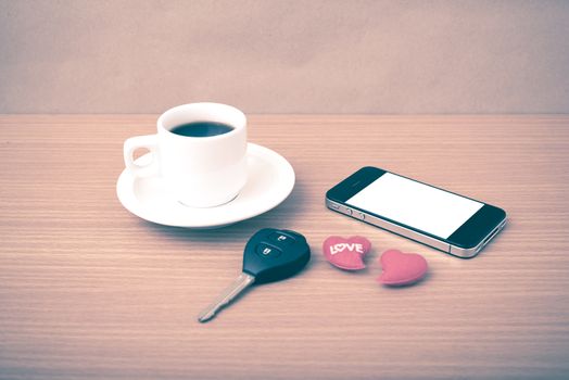 coffee phone car key and heart on wood table background vintage style
