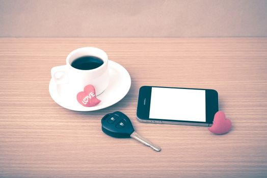 coffee phone car key and heart on wood table background vintage style
