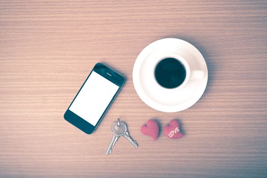 coffee phone key and heart on wood table background vintage style