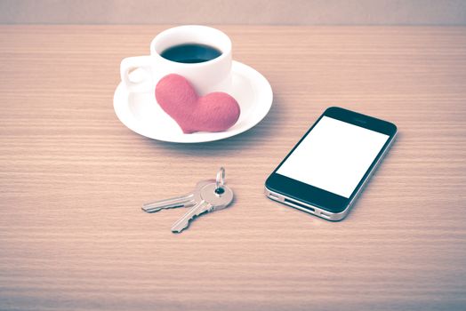 coffee phone key and heart on wood table background vintage style