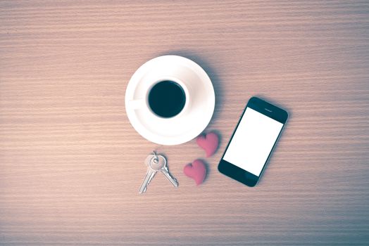coffee phone key and heart on wood table background vintage style