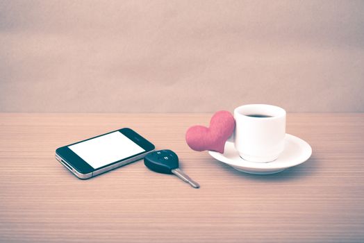 coffee phone car key and heart on wood table background vintage style