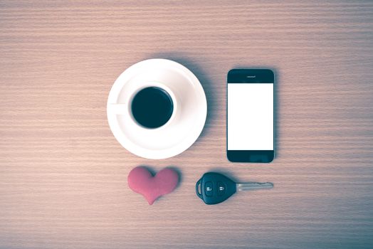 coffee phone car key and heart on wood table background vintage style
