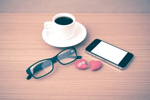 coffee,phone,eyeglasses and heart on wood table background vintage style