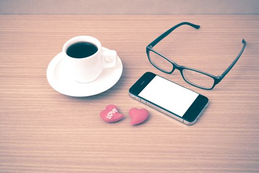 coffee,phone,eyeglasses and heart on wood table background vintage style