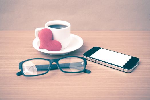 coffee,phone,eyeglasses and heart on wood table background vintage style
