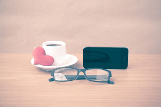 coffee,phone,eyeglasses and heart on wood table background vintage style