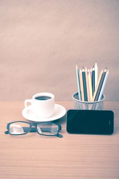 coffee,phone,eyeglasses and pencil on wood table background vintage style