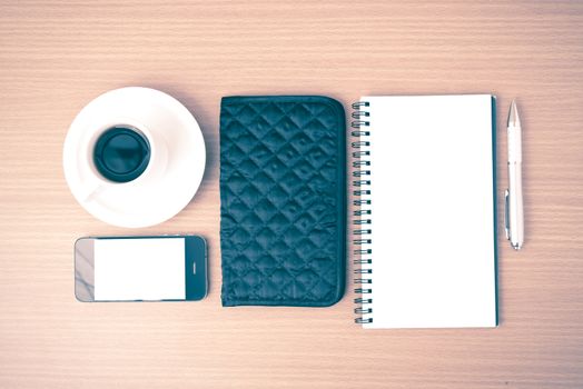 coffee,phone,notepad and wallet on wood table background vintage style