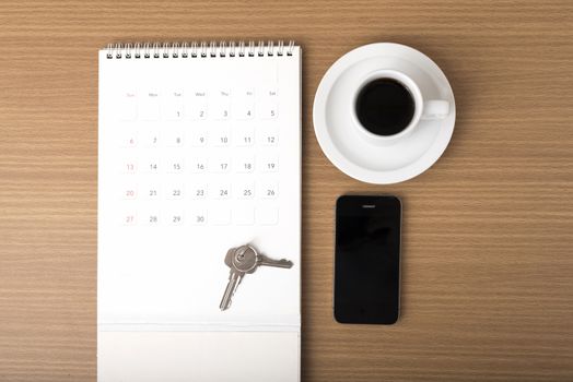 coffee,phone,key and calendar on wood table background