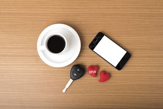 coffee phone car key and heart on wood table background