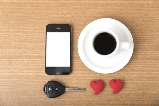 coffee phone car key and heart on wood table background