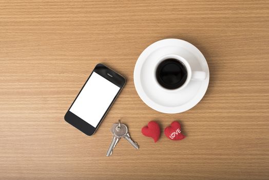 coffee phone key and heart on wood table background