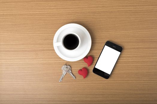 coffee phone key and heart on wood table background
