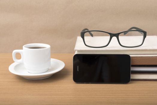 coffee,phone,stack of book and eyeglasses on wood table background