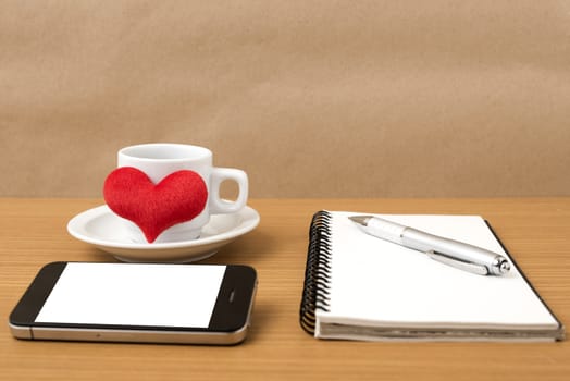 coffee,phone,notepad and heart on wood table background