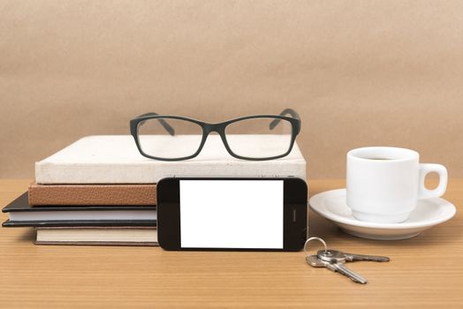 coffee,phone,key,eyeglasses and stack of book on wood table background