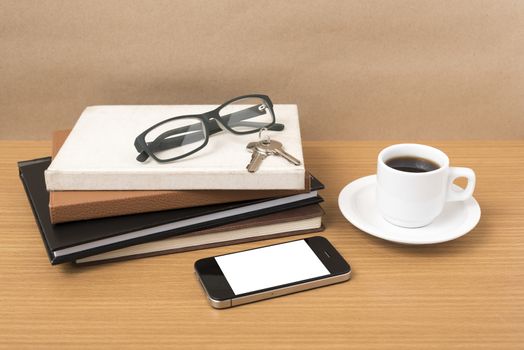 coffee,phone,key,eyeglasses and stack of book on wood table background