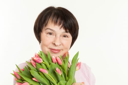 the beautiful mature woman with a bouquet of tulips