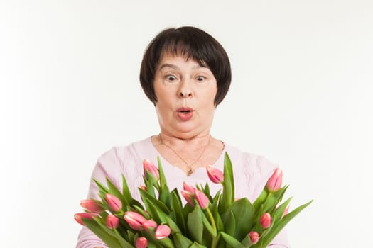 the beautiful mature woman is surprised to a bouquet of tulips