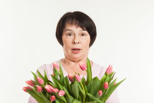 the beautiful mature woman is surprised to a bouquet of tulips