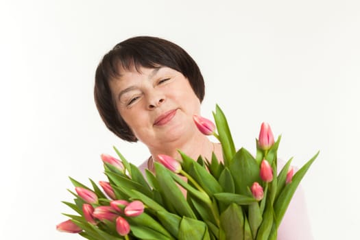 the beautiful mature woman admires to a bouquet of tulips