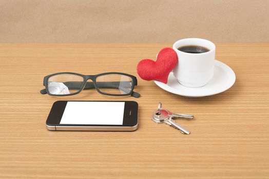 coffee,phone,eyeglasses,key and heart on wood table background