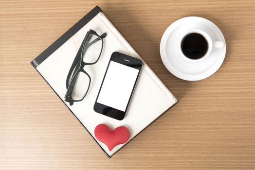 coffee,phone,eyeglasses,stack of book and heart on wood table background