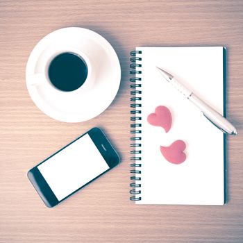 coffee,phone,notepad and heart on wood table background vintage style