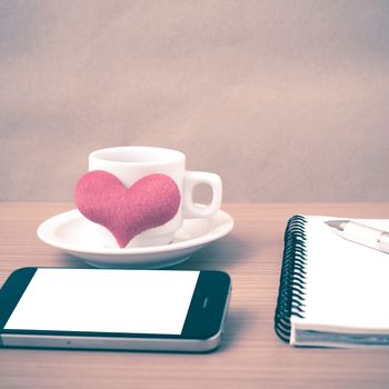 coffee,phone,notepad and heart on wood table background vintage style