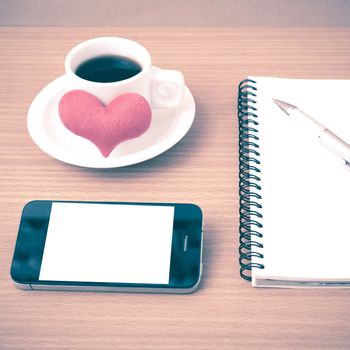 coffee,phone,notepad and heart on wood table background vintage style