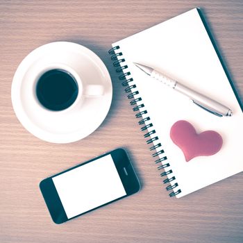 coffee,phone,notepad and heart on wood table background vintage style