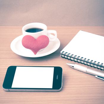 coffee,phone,notepad and heart on wood table background vintage style