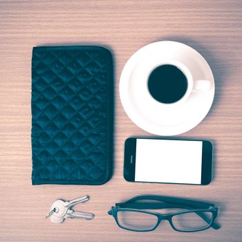 coffee,phone,key,eyeglasses and wallet on wood table background vintage style
