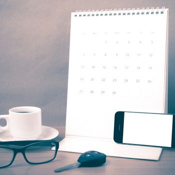 coffee,phone,car key,eyeglasses and calendar on wood table background vintage style