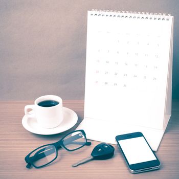 coffee,phone,car key,eyeglasses and calendar on wood table background vintage style