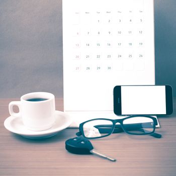 coffee,phone,car key,eyeglasses and calendar on wood table background vintage style
