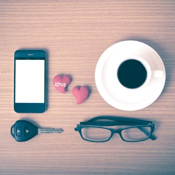 coffee,phone,eyeglasses,car key and heart on wood table background vintage style