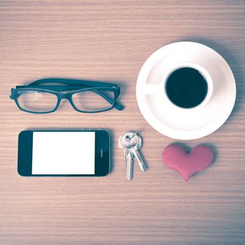 coffee,phone,eyeglasses,key and heart on wood table background vintage style