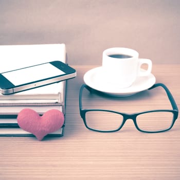 coffee,phone,eyeglasses,stack of book and heart on wood table background vintage style