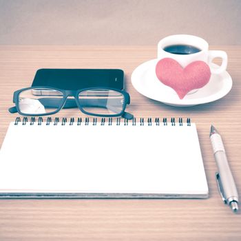 coffee,phone,eyeglasses,notepad and heart on wood table background vintage style