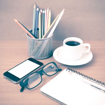 coffee,phone,eyeglasses,notepad and color pencil on wood table background vintage style