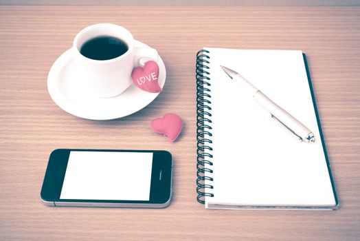 coffee,phone,notepad and heart on wood table background vintage style