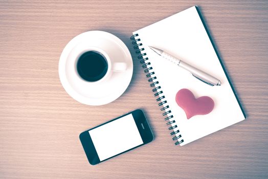 coffee,phone,notepad and heart on wood table background vintage style