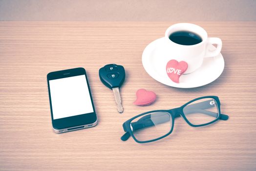 coffee,phone,eyeglasses,car key and heart on wood table background vintage style