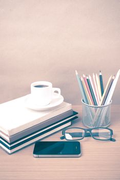 coffee,phone,eyeglasses,stack of book and color pencil on wood table background vintage style